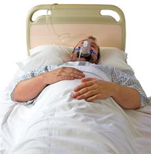 man in hospital bed with an oxygen mask