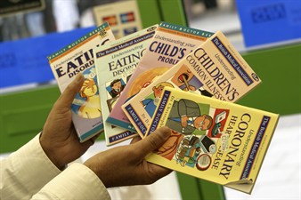 hands holding various child health booklets