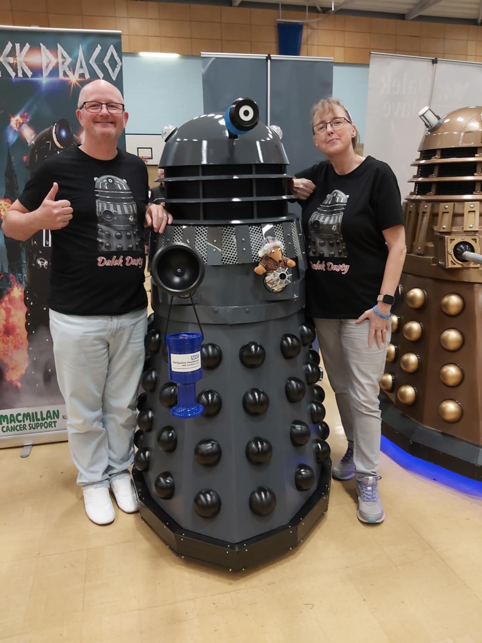 Samantha and Adrian Kennedy standing either side of their homemade Dalek, a collecting tin in view